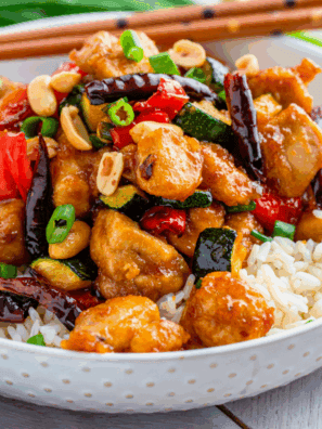 Air fryer crispy Kung Pao chicken with peanuts and vegetables on a plate.