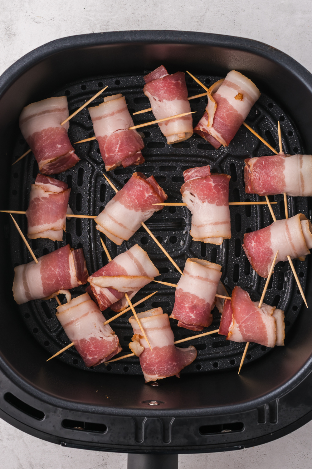 Bacon Wrapped Dates in air fryer basket.