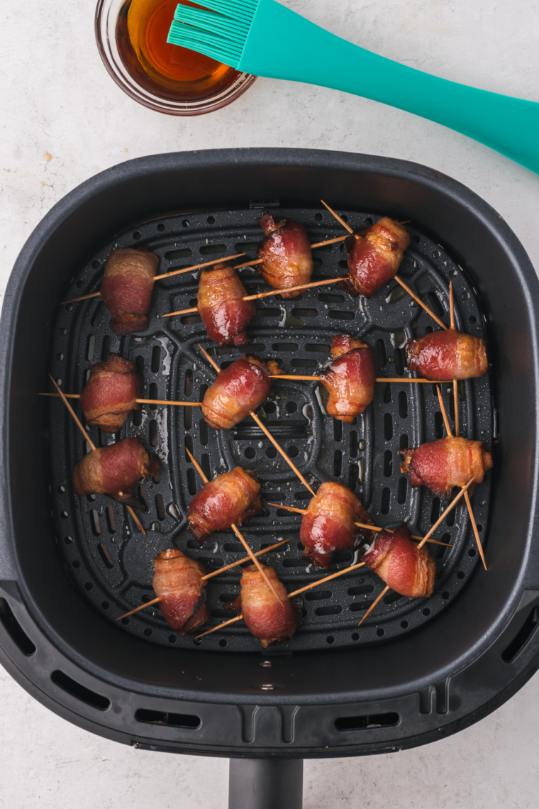 Air Fryer Bacon Wrapped Dates in air fryer basket.