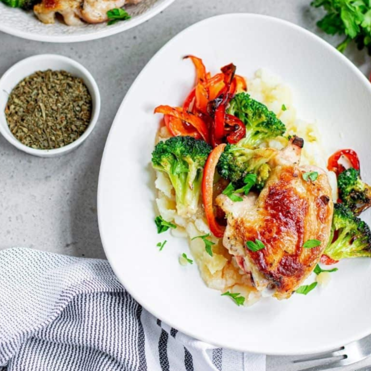 Close-up of golden brown air fryer chicken thighs and roasted vegetables