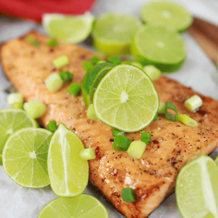 Finished garlic lime butter salmon topped with herbs and lime wedges