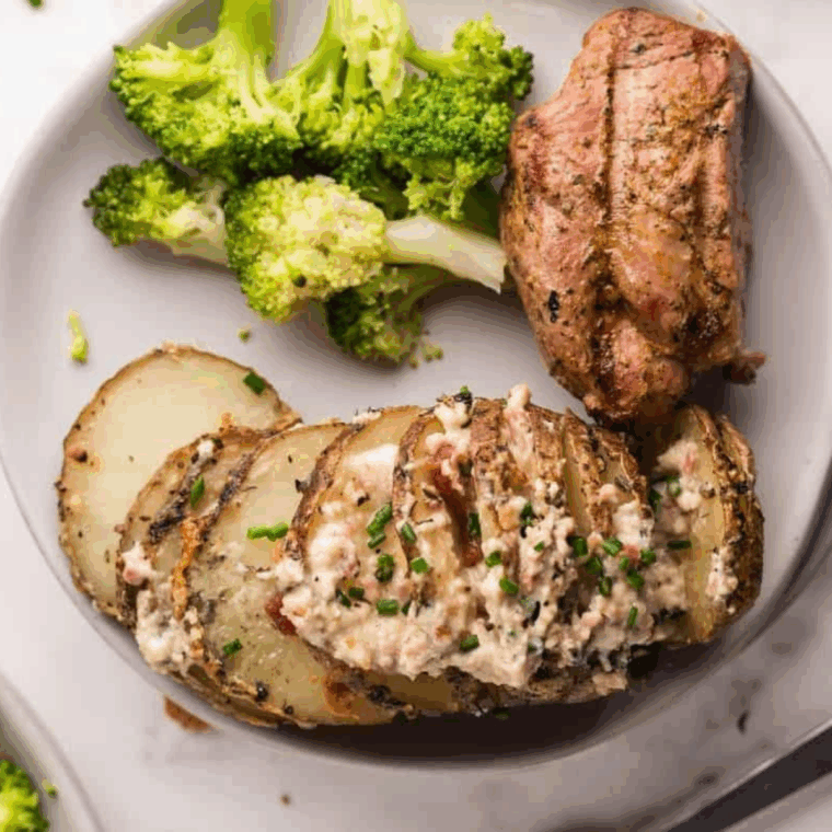 Crispy Hasselback potatoes topped with melted bleu cheese, bacon, and fresh chives