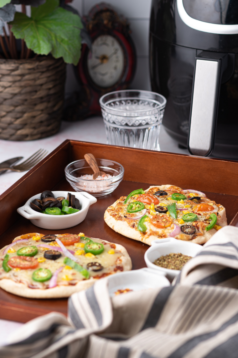 Close-up of a 5-minute air fryer pita pizza with bubbly golden cheese and a crispy pita crust