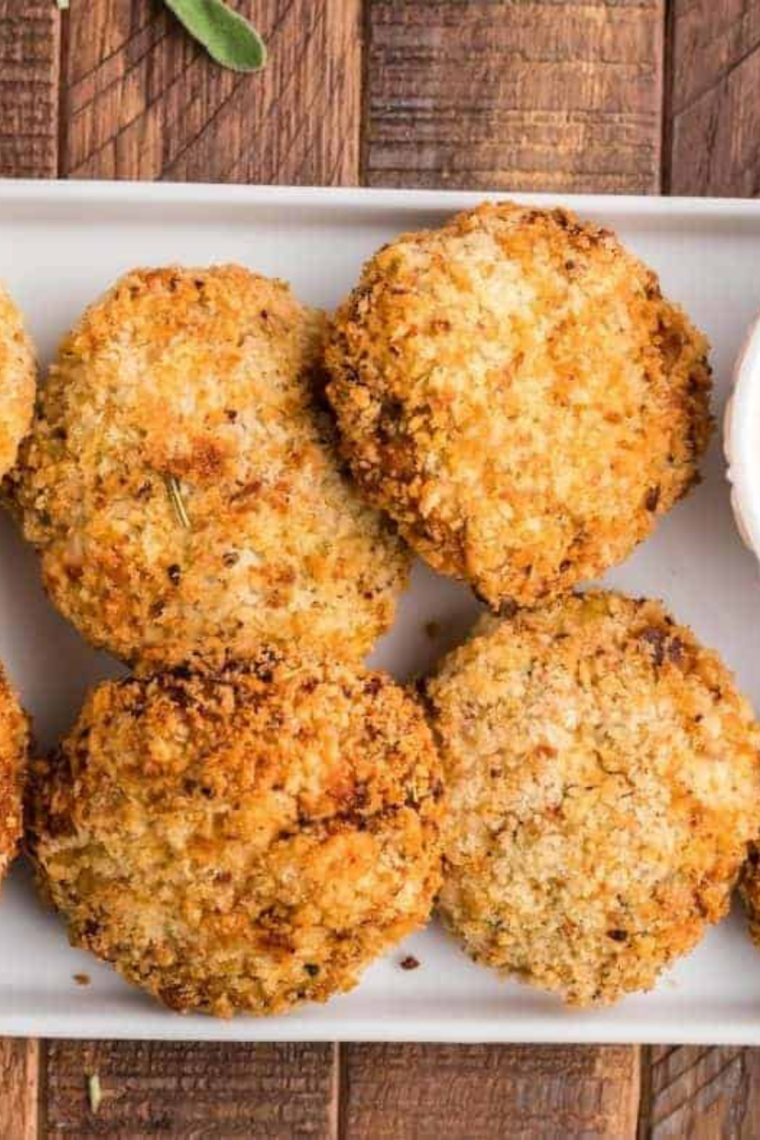Close-up of a crispy air fryer turkey croquette dipped in cranberry sauce