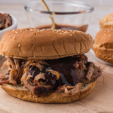 Copycat Mission BBQ pulled pork piled high on a toasted brioche bun with coleslaw and barbecue sauce