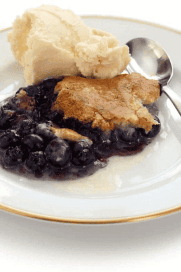 Easy air fryer blueberry cobbler with bubbling blueberries and golden crust in a baking dish.