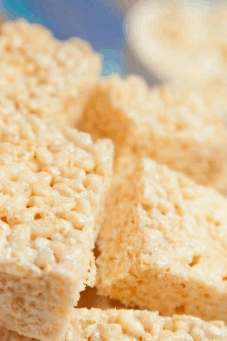 Golden, gooey Rice Krispie Treats stacked on a plate