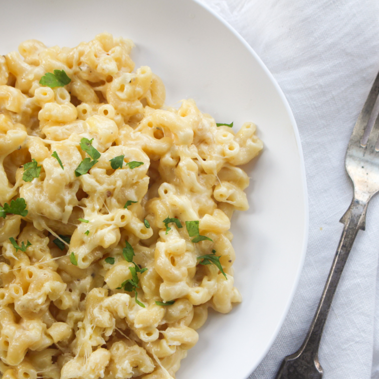 Delicious Instant Pot Panera-style mac and cheese served in a bowl, featuring creamy cheese sauce and elbow pasta, garnished with parsley.