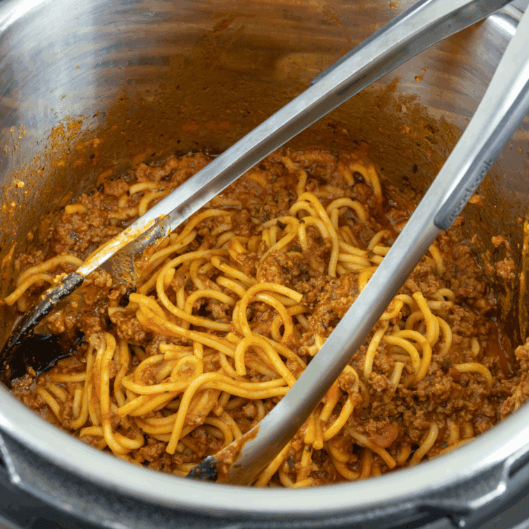 Mixing the sauce and pasta into the Instant Pot Bowl.