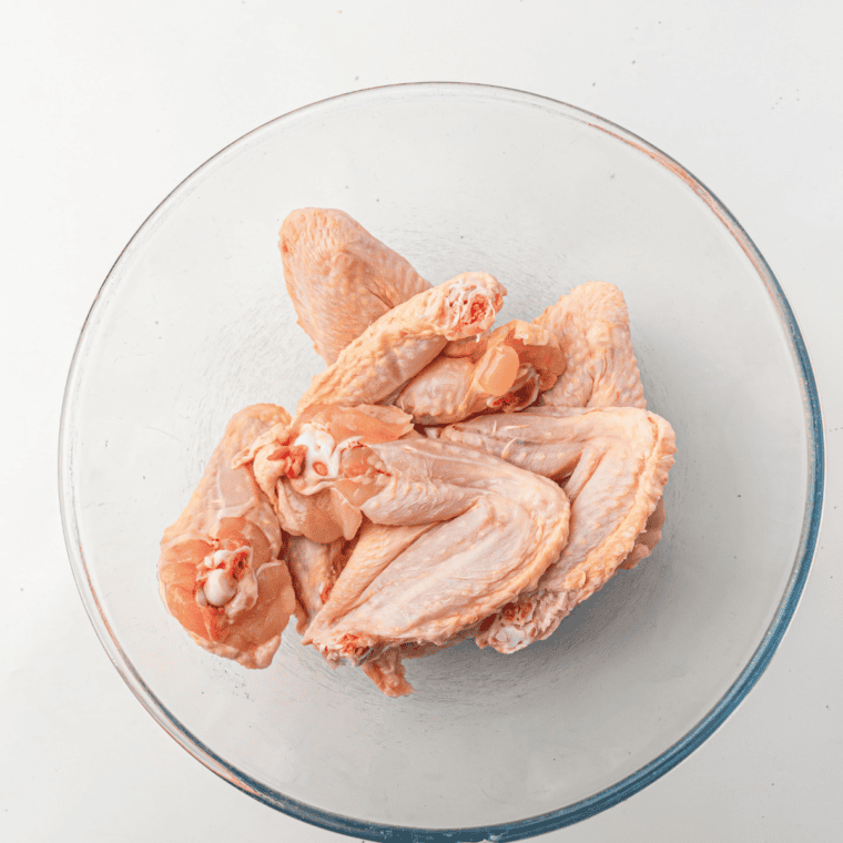 Patting raw chicken wings dry with paper towels for Ninja Crispi wings