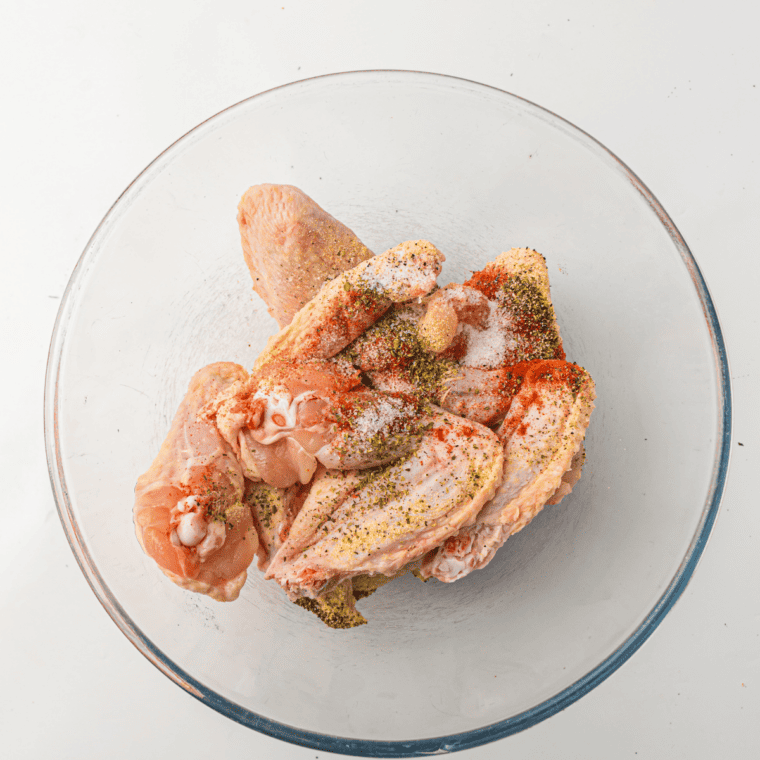 Seasoned chicken wings arranged in a single layer on Ninja Crispi crisper plate