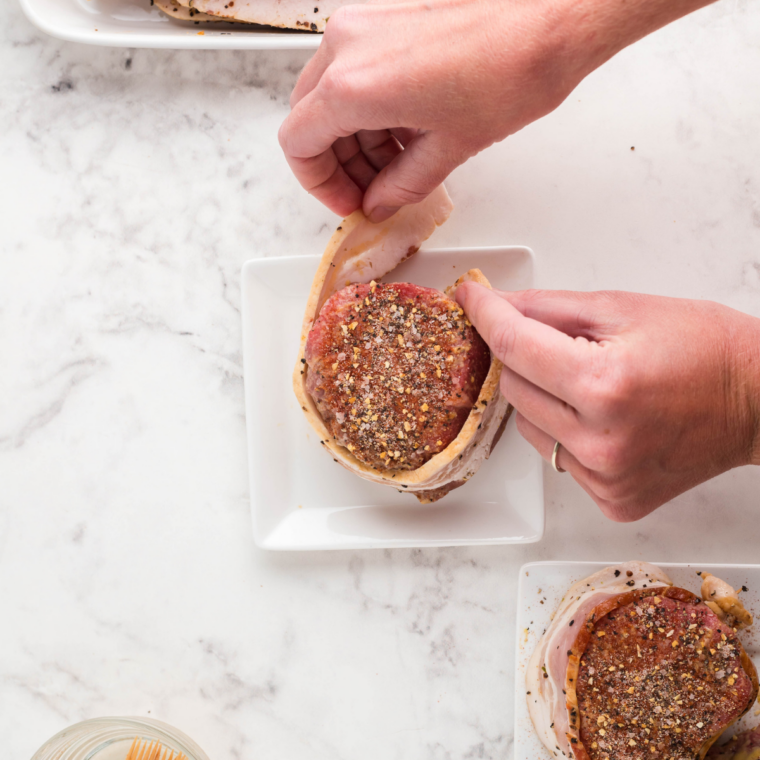 Steaks resting on the counter to reach room temperature for even cooking and a juicy center in the air fryer.