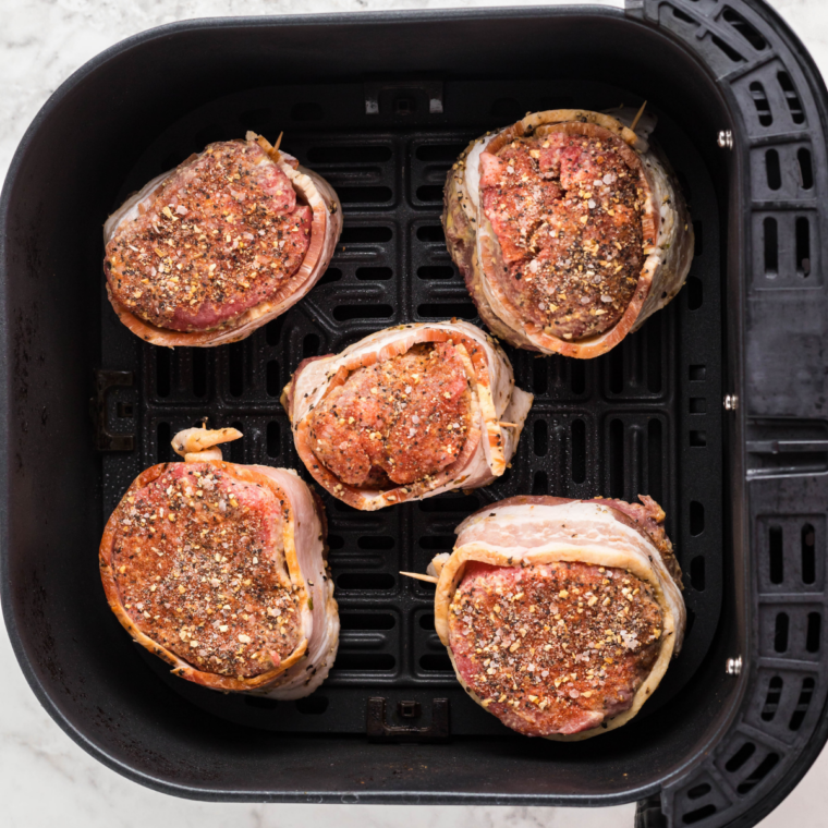 Raw steaks being patted dry, coated with olive oil, and generously seasoned on all sides for a perfect crust.