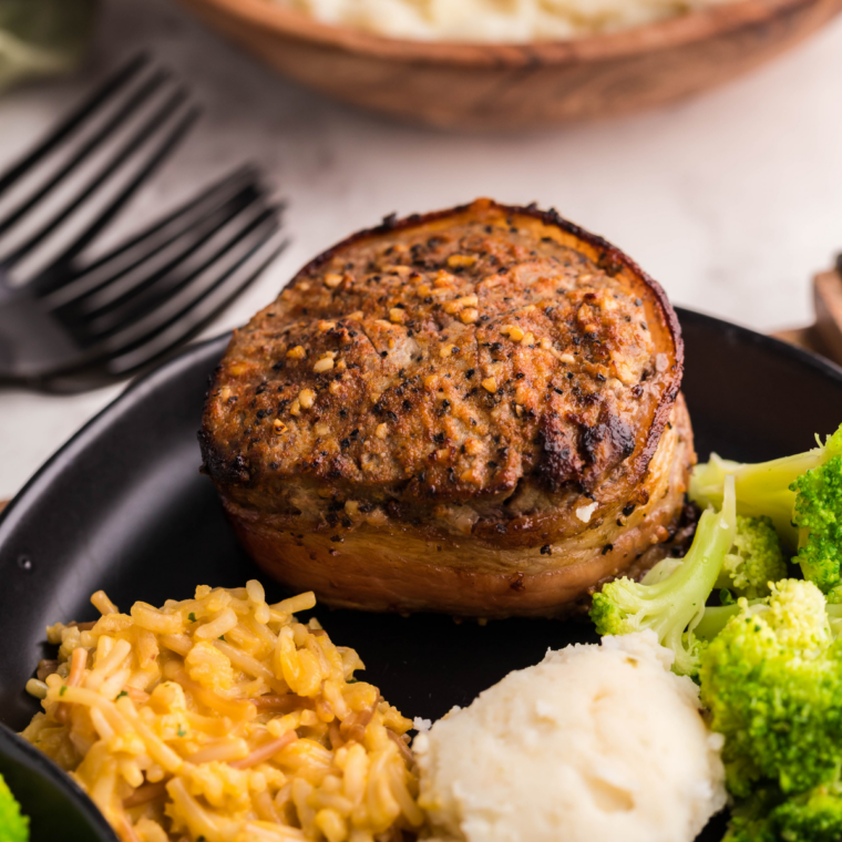 Plated air fryer filet mignon topped with butter and resting before serving