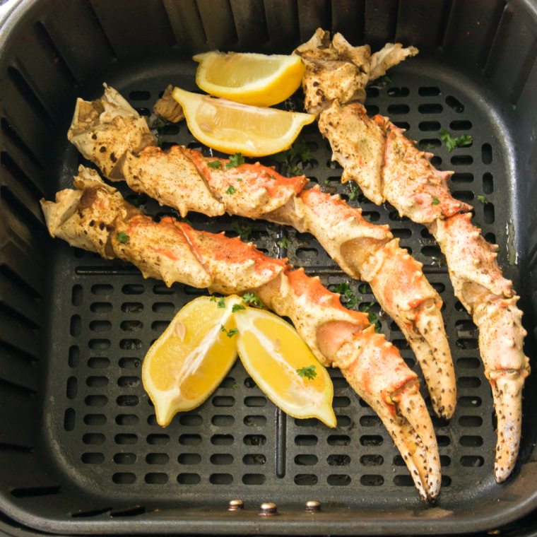 A close-up of crispy, golden-brown air fryer crab legs served with garlic butter.