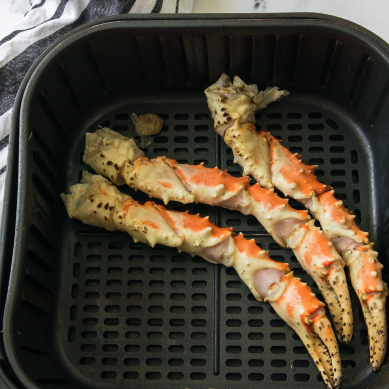 Rinsing and scrubbing snow crab legs, then tossing with olive oil and seasoning