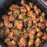 Golden air fryer garlic parmesan chicken bites in an air fryer basket, fresh from cooking