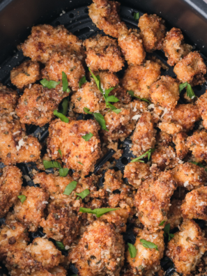 Golden air fryer garlic parmesan chicken bites in an air fryer basket, fresh from cooking