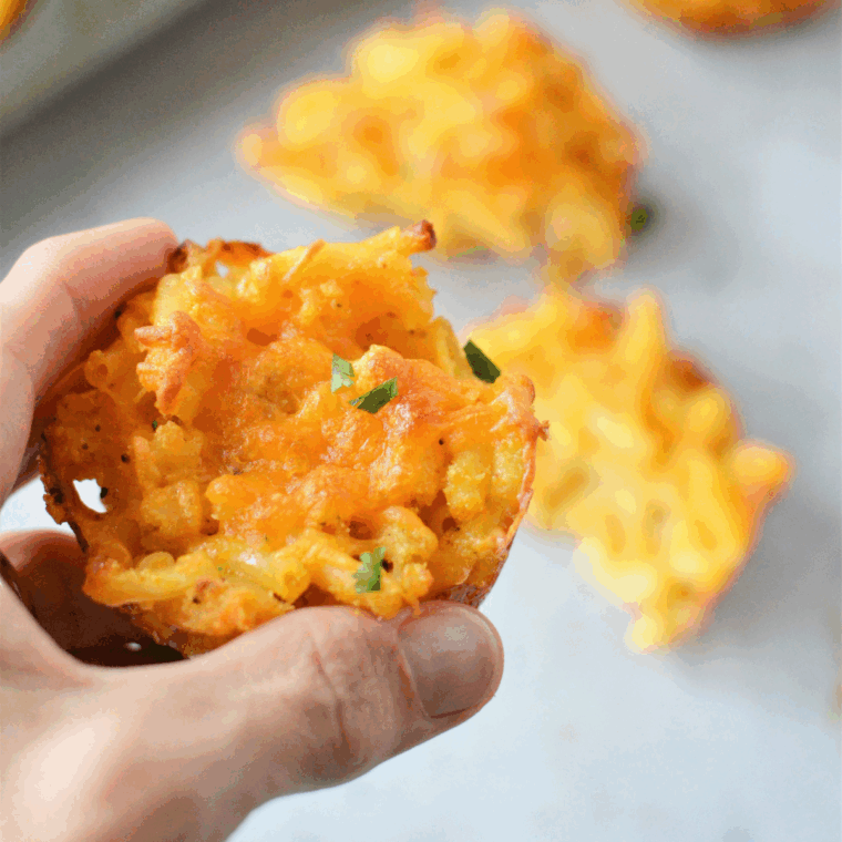 Cheesy air fryer macaroni and cheese muffins in a muffin tin, golden and crispy on the edges.