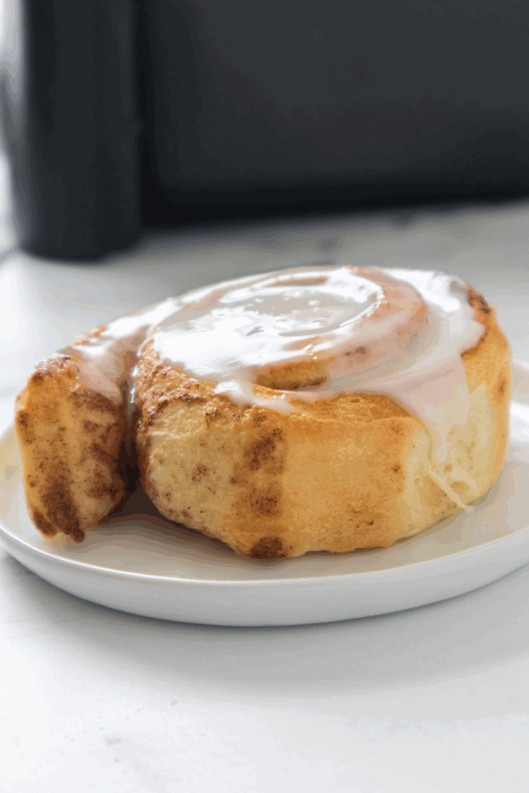 Golden brown Pillsbury cinnamon rolls cooked in the air fryer and topped with sweet icing.