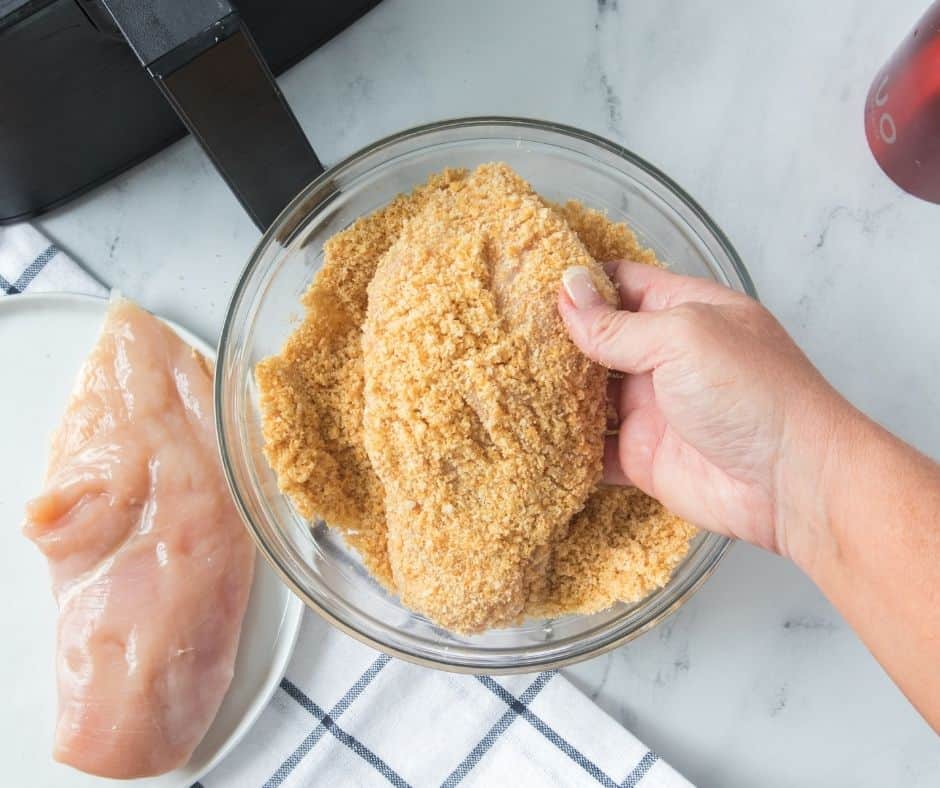 Air Fryer Ritz Cracker Chicken Start by laying out your chicken on a cutting board, trim all of the fat, off. Then dip the chicken in the coating mix.