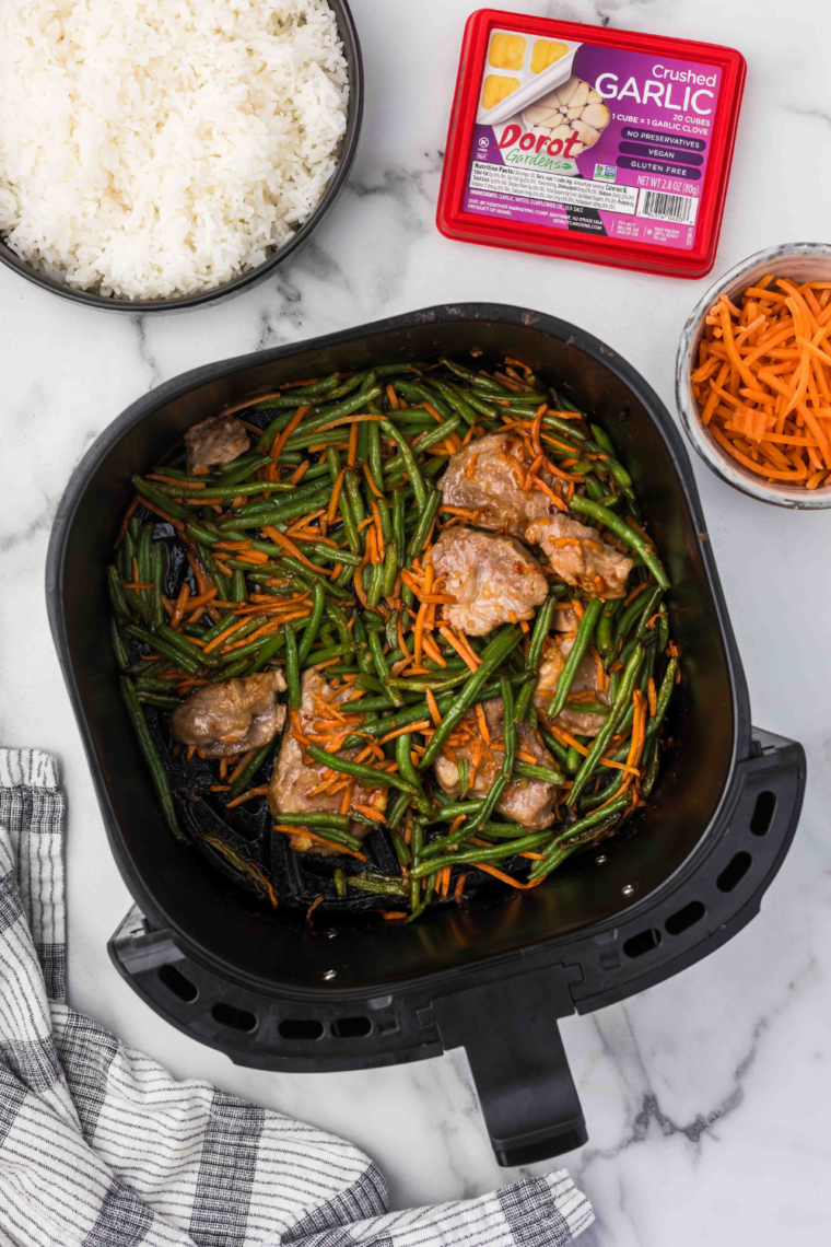 "Placing marinated pork chops in the air fryer basket"