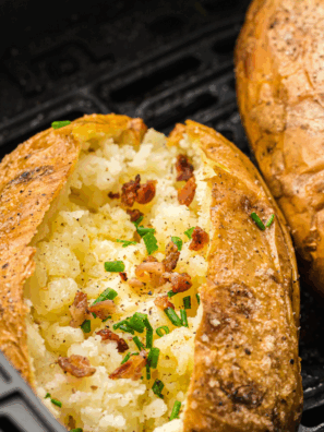 Crispy Copycat Outback Baked Potatoes with salt-crusted skins and fluffy insides served on a white plate with butter and chives.