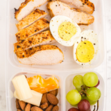 A copycat Starbucks protein box with air fryer chicken breast, hard-boiled eggs, cheddar, grapes, and almonds. About 40 grams of protein per box for roughly $2.50 — nearly double the original at a third of the price.