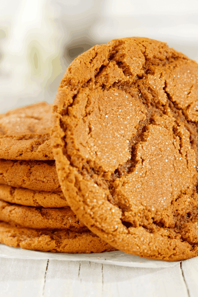 Freshly baked air fryer gingersnap cookies, golden brown, soft in the center, cooling on a wire rack, with a warm, spiced aroma.