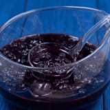 Jar of homemade Instant Pot mixed berry jam with a spoon