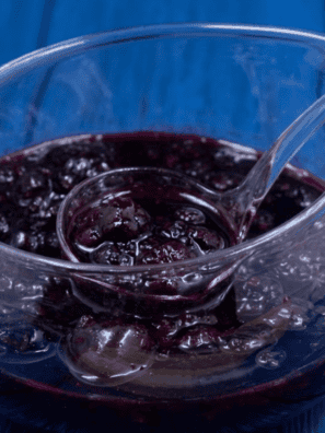 Jar of homemade Instant Pot mixed berry jam with a spoon