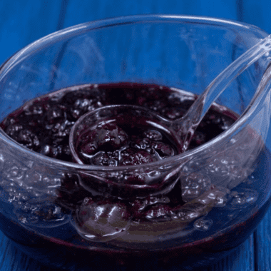 Jar of homemade Instant Pot mixed berry jam with a spoon