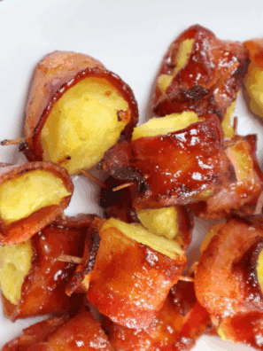Air Fryer Bacon Wrapped Pineapple bites with crispy bacon and caramelized edges, served on a white plate.