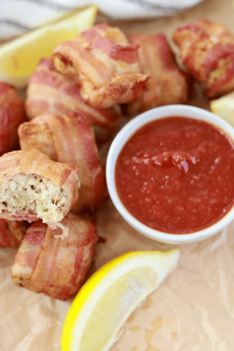 Bacon-wrapped crab rolls cooked in an air fryer, golden and crispy. Served on a plate, ready to enjoy with a dipping sauce.