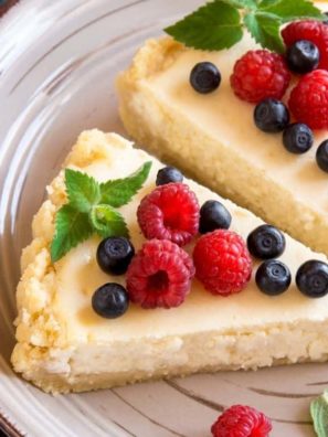 slices of cheesecake topped with fresh berries and mint leaves