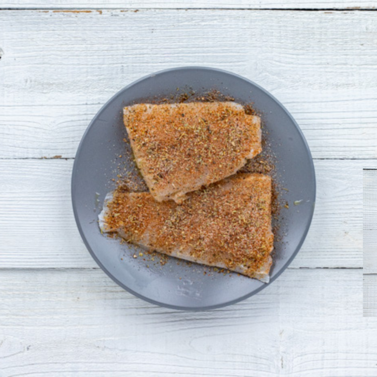 patting sea bass dry and seasoning with salt pepper and spices