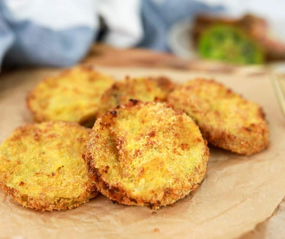 Close up of Air Fryer breaded Fried Green Tomatoes on a wooden chopping board. 