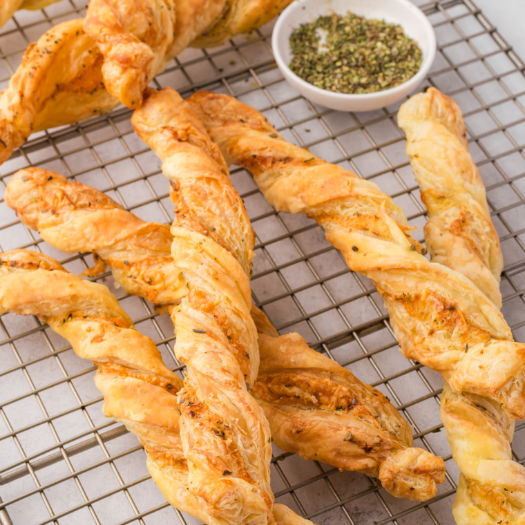 Golden, flaky Air Fryer Ham and Cheese Twists with melted cheese and ham, served on a plate.