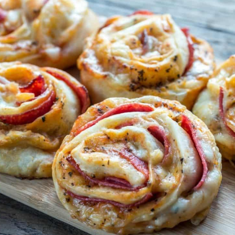 Plate of crispy Air Fryer Homemade Pizza Rolls filled with cheese and pepperoni, served with marinara sauce for dipping