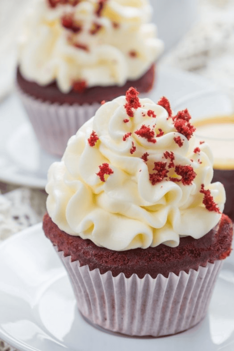 Freshly baked Air Fryer Red Velvet Cupcakes with smooth cream cheese frosting and bright red cake inside.