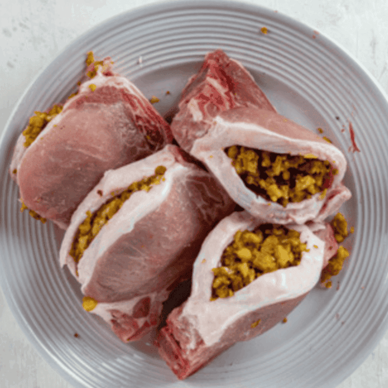 Fill the pocket of each pork chop with prepared stuffing and press the edges together to secure the filling in place.