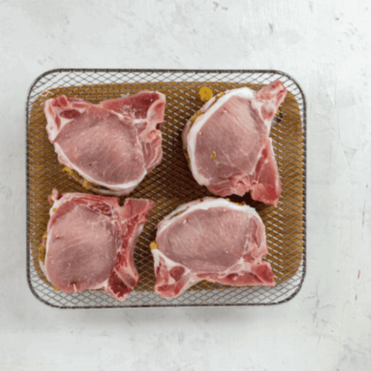 Place stuffed pork chops in the air fryer basket, cook for 10-15 minutes, flipping halfway, and check for an internal temperature of 145°F (63°C).