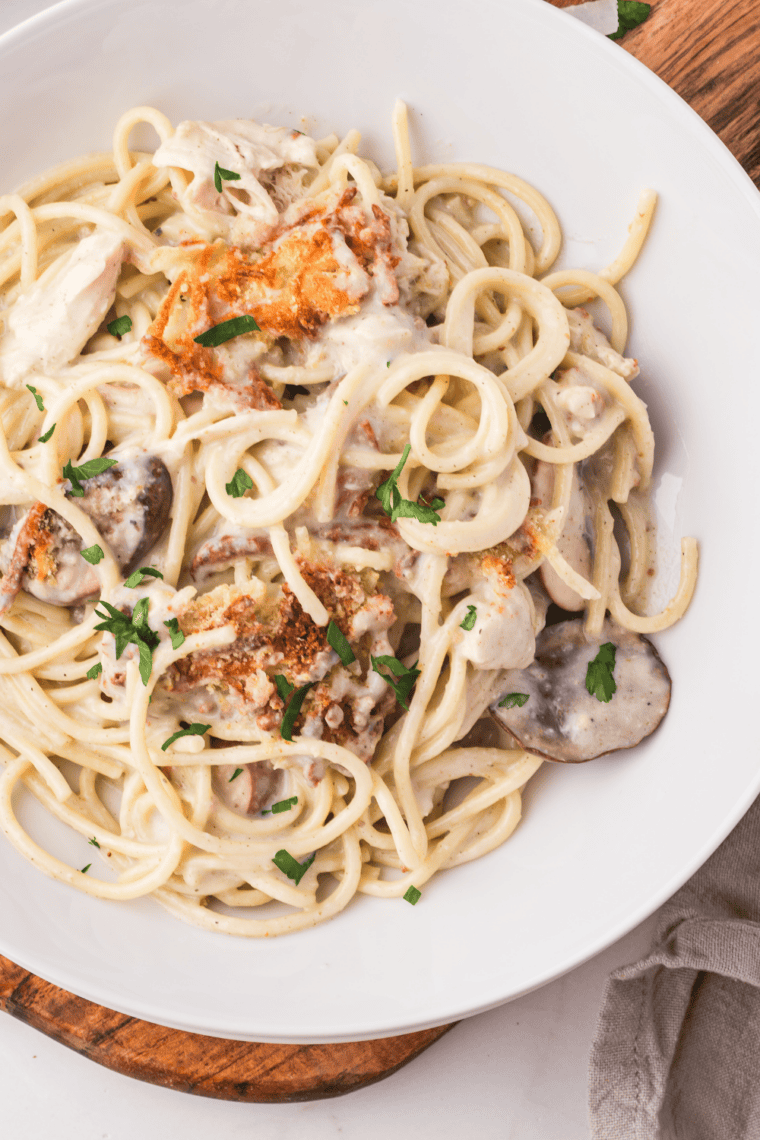 Close-up of creamy turkey tetrazzini served from an air fryer baking dish with golden melted cheese.