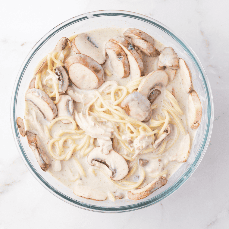 Creamy tetrazzini sauce with cream cheese, broth, and seasonings simmering in a skillet.