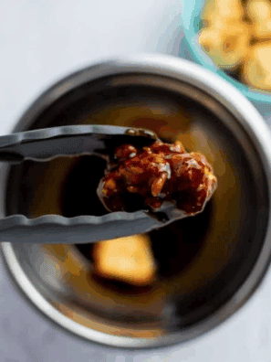 Plate of crispy Buffalo Wild Wings-style cauliflower wings coated in tangy buffalo sauce, garnished with parsley and served with dipping sauce.