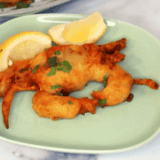 Air fryer crispy soft shell crab on a plate with lemon wedges