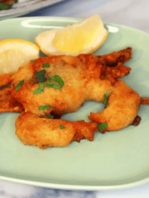 Air fryer crispy soft shell crab on a plate with lemon wedges