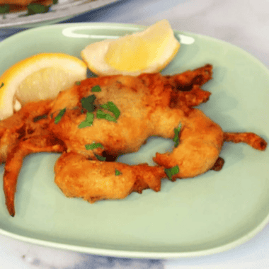 Air fryer crispy soft shell crab on a plate with lemon wedges