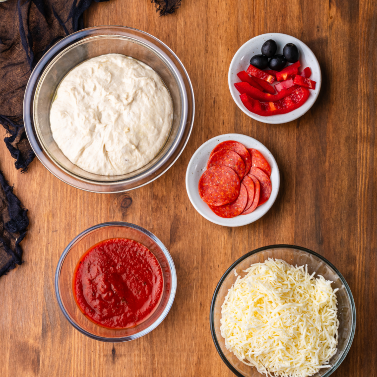 Ingredients needed for Easy Air Fryer Homemade Pepperoni Pizza Rolls on kitchen table.