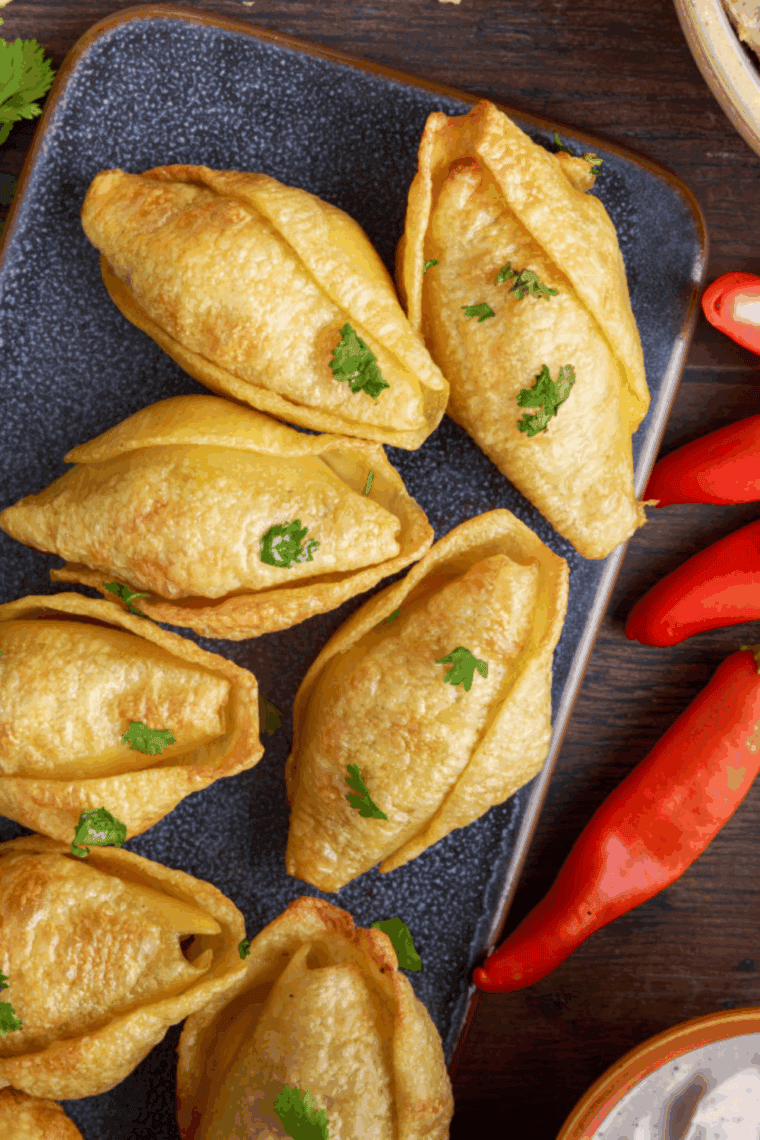 Air fryer taco stuffed pasta shells filled with pork carnitas and melted cheddar cheese, golden brown and served on a plate.